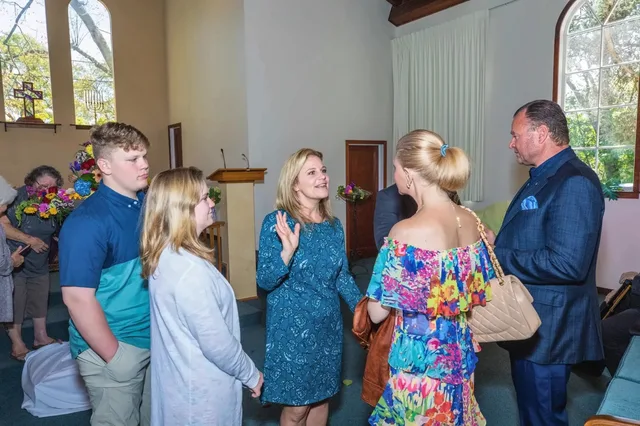 Church members and visitors talking together in the sanctuary after a service