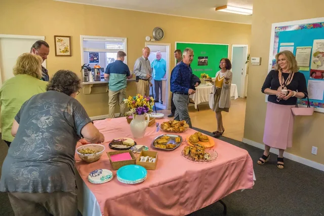 Friends gathering around a table of homemade refreshments in the fellowship hall