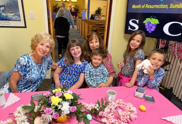 Adults and children smiling together at an Easter gathering